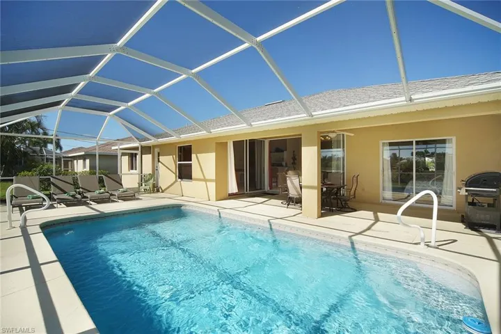 Outdoor pool with area for grilling, a patio area, and glass enclosure