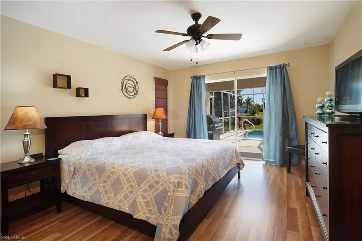 Bedroom with access to outside, wood finished floors, and a ceiling fan