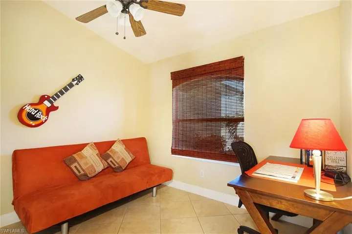 Office with baseboards, light tile patterned floors, and a ceiling fan