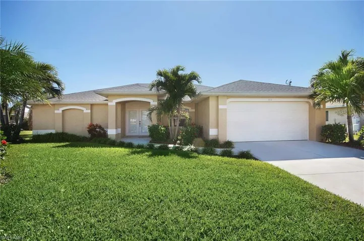 Single story home featuring driveway, french doors, an attached garage, stucco siding, and a front lawn