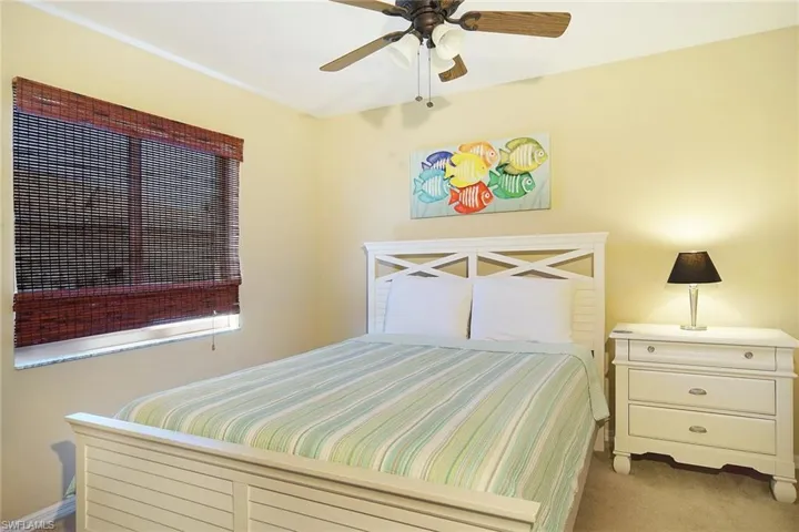 Bedroom with light carpet and a ceiling fan