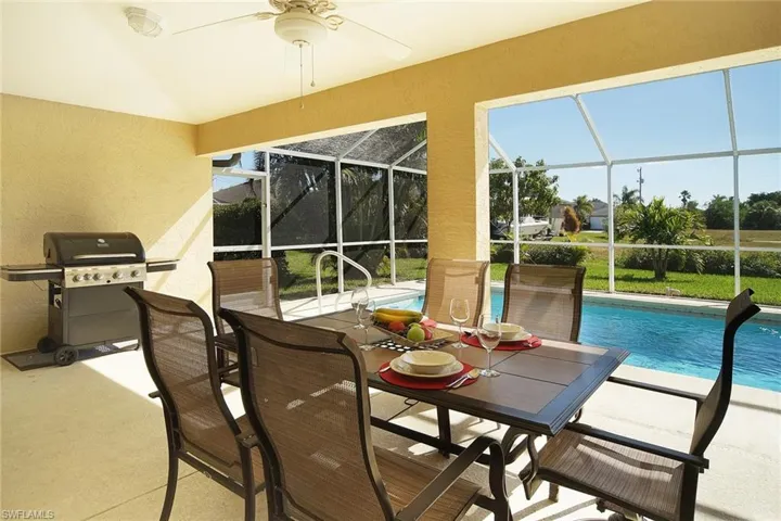Sunroom / solarium with outdoor dining area, a ceiling fan, and a swimming pool