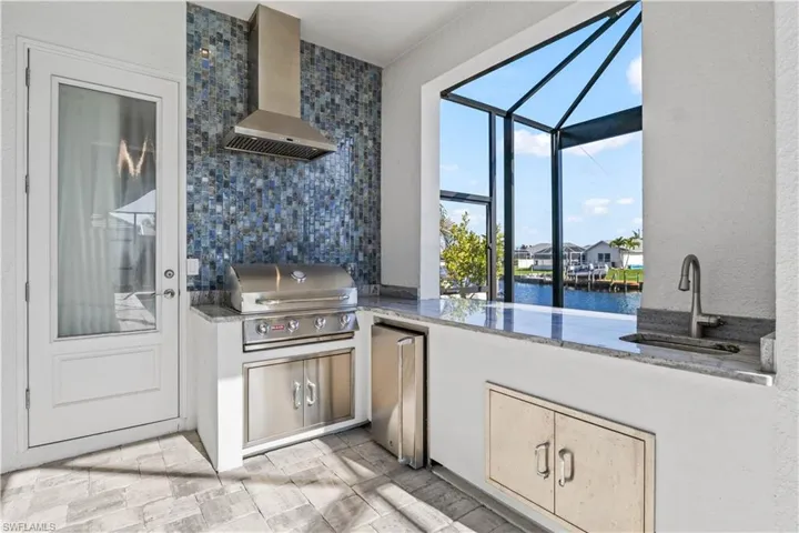 Not only is there an amazing chef's kitchen indoors but also a GREAT outdoor kitchen with seating area, fridge and sink!