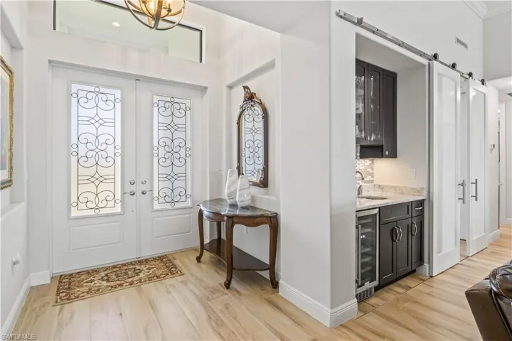 Double door entry with transom window and soaring ceilings provide natural light in abundance throughout the home.  Nice size foyer and beautiful ceramic wood tile planks accent the neutral color palette!
