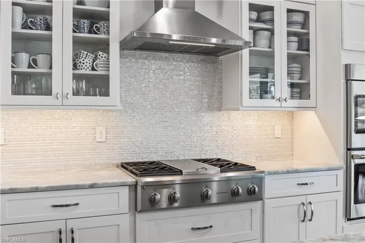 This kitchen was designed for a chef - gas burner stove, double ovens and look at the beautiful backsplash and counter tops - glass front cabinets are another design element that was well thought out!