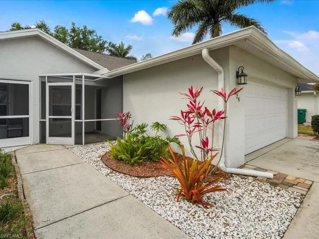 Doorway to property featuring stucco siding, an attached garage, and concrete driveway