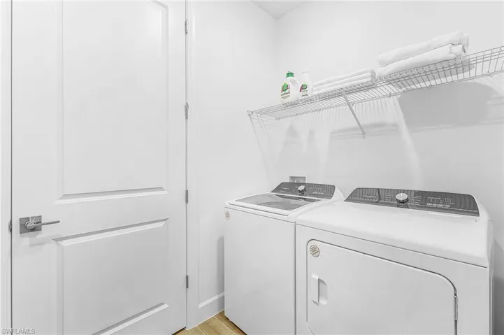 Dedicated laundry area featuring a white top-load washer and front-load dryer