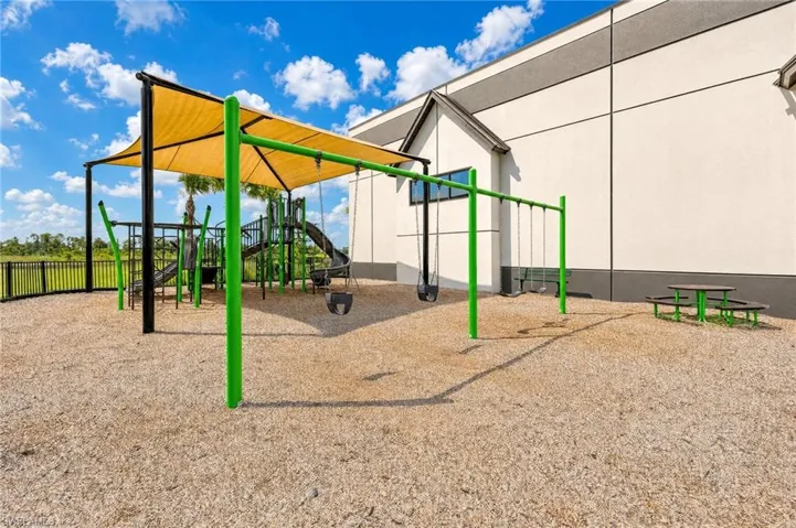 Outdoor covered play area with swings, playground and mulch