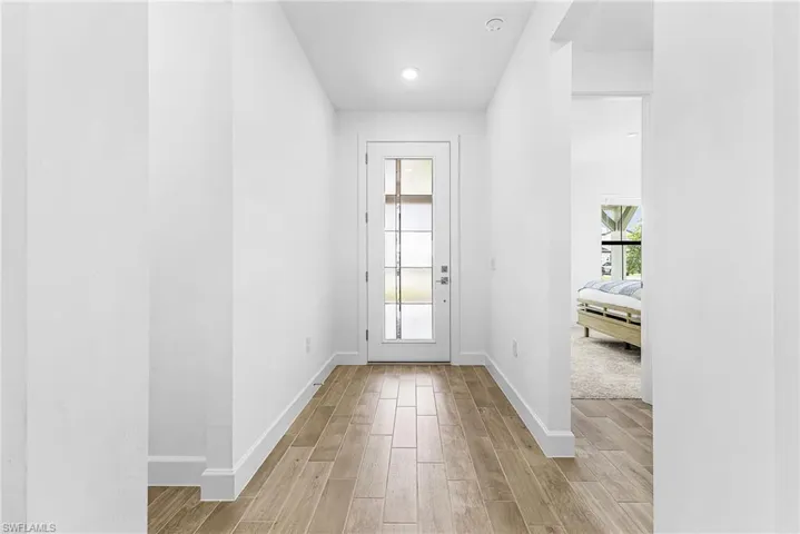 Entryway featuring wood-finish tile flooring, white baseboards, and bright white walls
