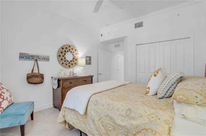 Bedroom featuring a closet, ceiling fan, tile floors, and crown molding
