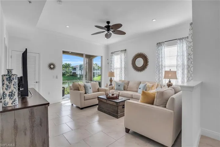 Living room with ceiling fan and light tile floors