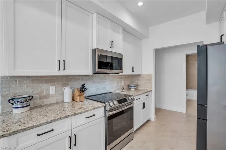 Kitchen with white cabinetry, tasteful backsplash, and stainless steel appliances
