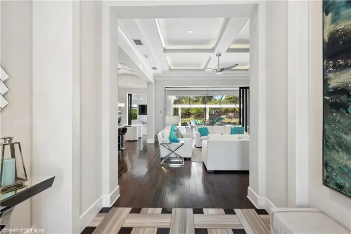 Living room with beam ceiling, coffered ceiling, and dark hardwood / wood-style flooring
