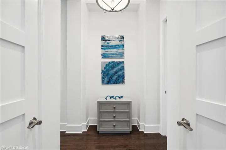 Hall with dark hardwood / wood-style flooring