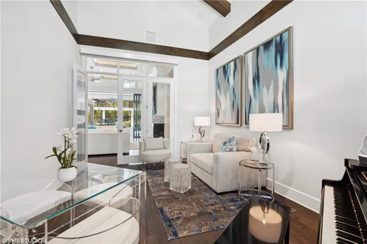 Living room featuring high vaulted ceiling, beamed ceiling, and hardwood / wood-style flooring