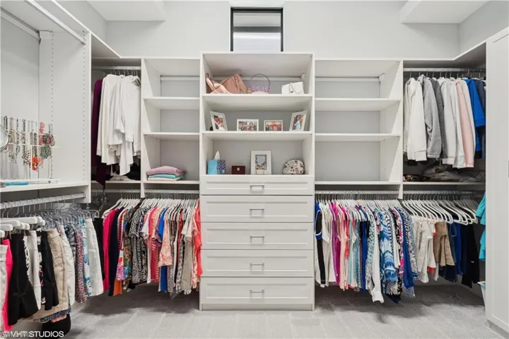 Spacious closet with light carpet