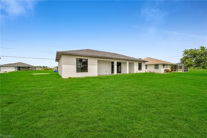Rear view of house featuring a yard