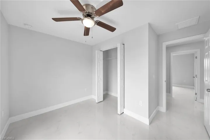 Unfurnished bedroom with ceiling fan, a closet, and light tile floors