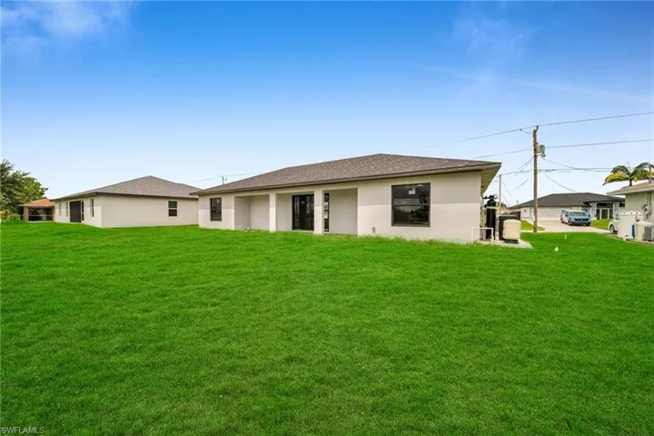 Rear view of house featuring a lawn