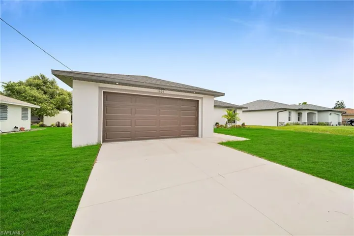 View of front of property featuring a garage and a front yard