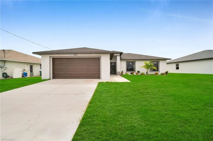View of front of house featuring a garage and a front yard
