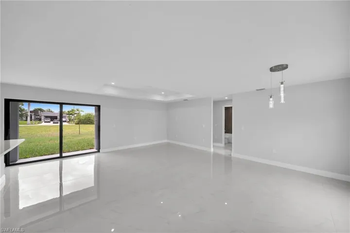 Spare room with a tray ceiling and tile floors