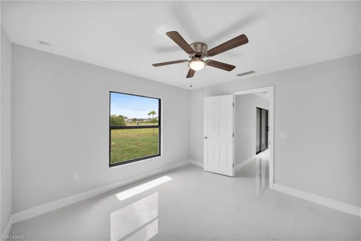Tiled spare room with ceiling fan