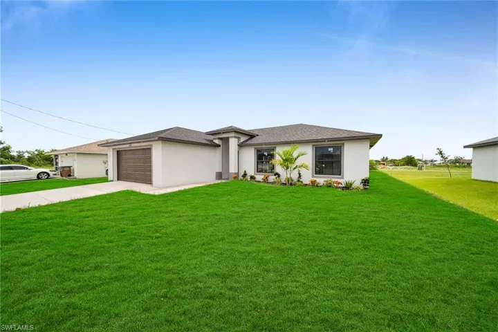 View of front of home featuring a garage and a front yard