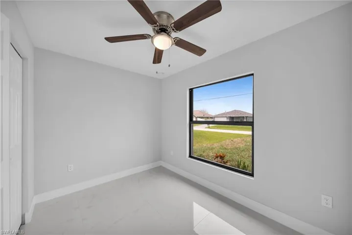 Spare room with ceiling fan and tile floors