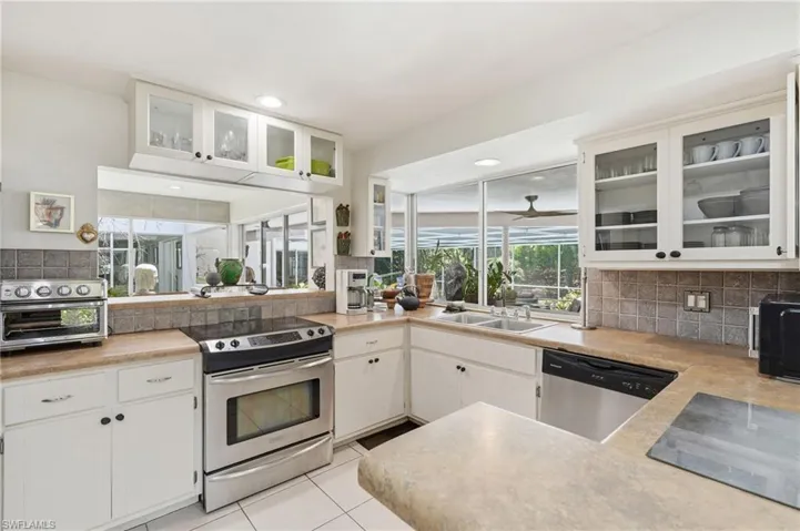 Kitchen featuring white cabinetry, light-toned countertops, a stainless steel range, and a built-in dishwasher