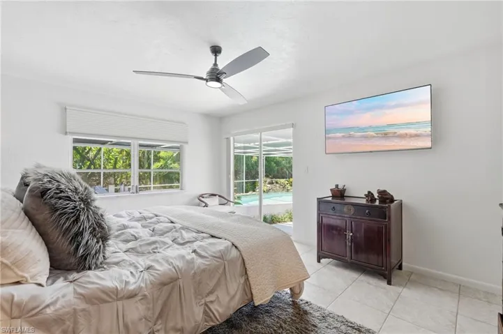 Bright interior featuring tile flooring, a modern ceiling fan, and large windows with privacy blinds