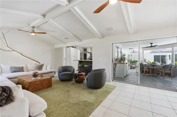 Vaulted ceiling with exposed beams and ceiling fans