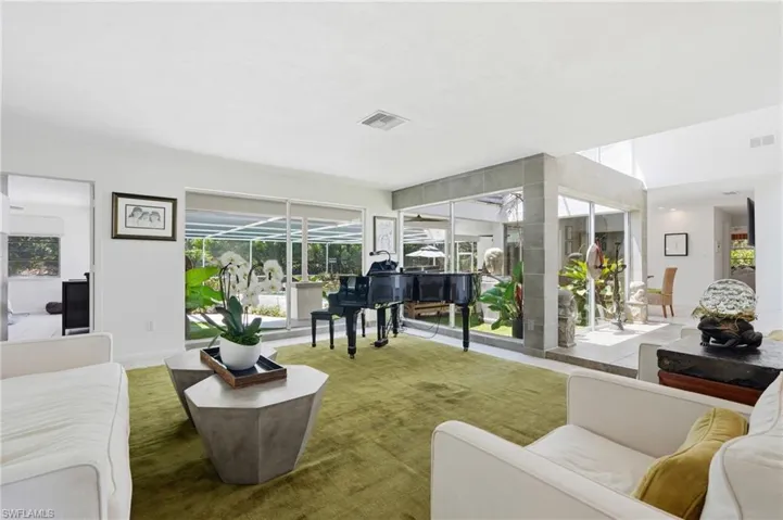 Open concept living space featuring white walls and a large area rug
