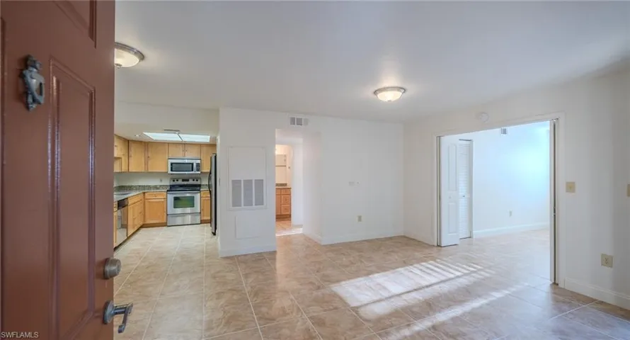 Kitchen with stainless steel appliances, light tile patterned floors, and light countertops