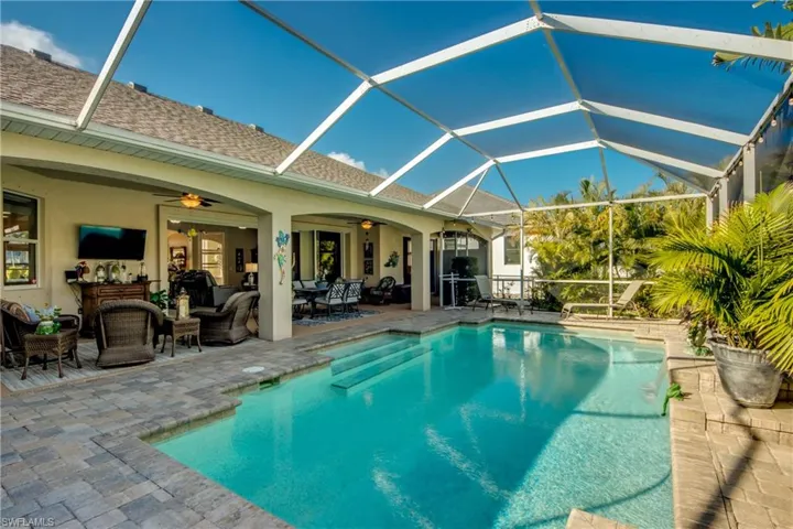 View of swimming pool featuring outdoor lounge area, a patio, ceiling fan, and a lanai