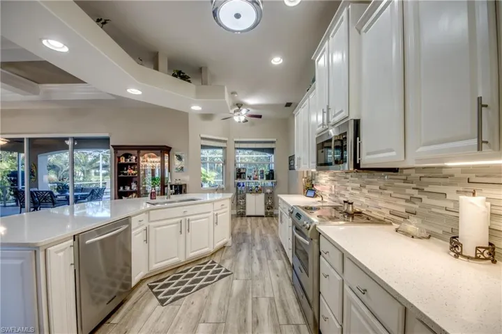 Kitchen featuring ceiling fan, light hardwood / wood-style floors, white cabinetry, and appliances with stainless steel finishes