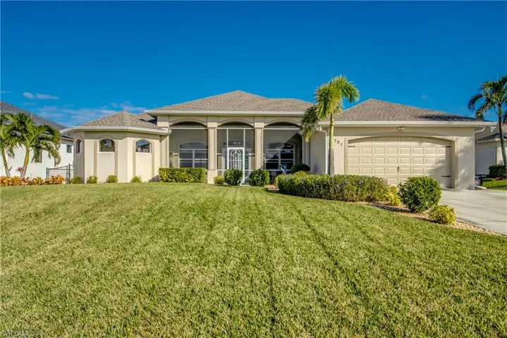 View of front of home featuring a garage and a front lawn