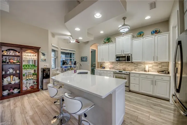 Kitchen with light hardwood / wood-style floors, white cabinetry, sink, and appliances with stainless steel finishes