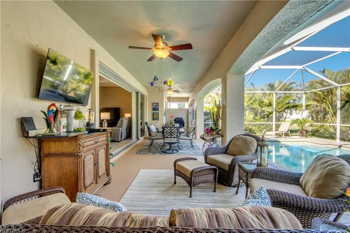 View of patio / terrace featuring an outdoor living space, an outdoor kitchen, ceiling fan, and a lanai