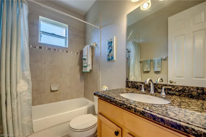 Full bathroom with vanity, toilet, and shower / bathtub combination with curtain