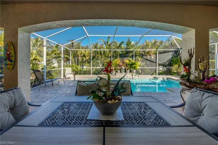 View of swimming pool featuring glass enclosure and a patio area