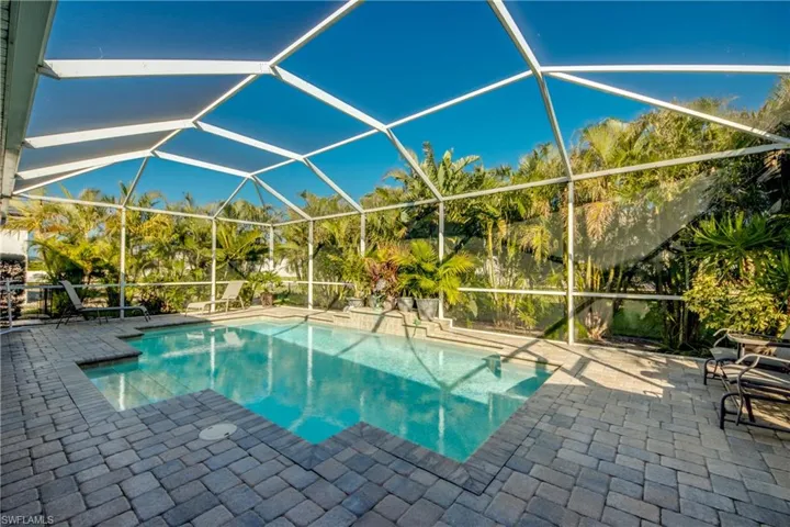 View of swimming pool featuring glass enclosure and a patio area