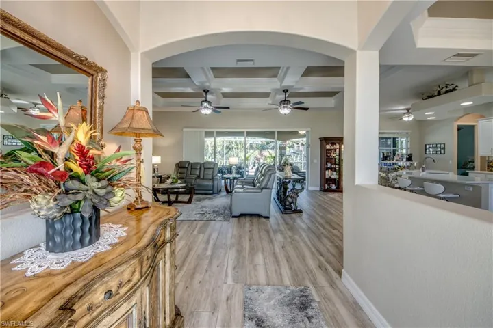 Living room with beam ceiling, ceiling fan, sink, coffered ceiling, and light hardwood / wood-style floors