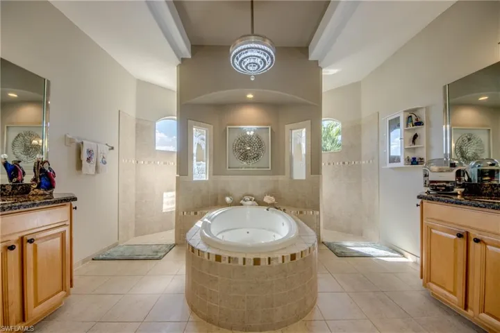 Bathroom with tile patterned floors, separate shower and tub, and vanity
