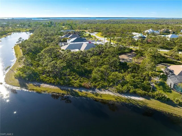 Aerial view of property and surrounding area featuring a large body of water and a forest