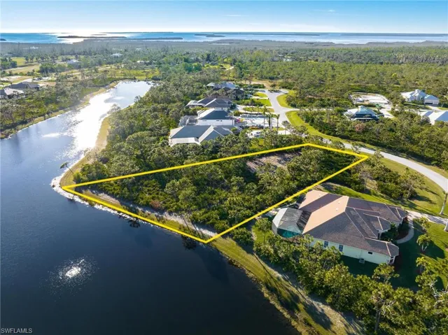 Aerial perspective of suburban area featuring a nearby body of water and property boundaries highlighted
