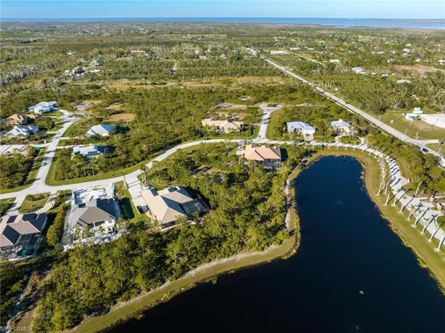 Aerial view of property and surrounding area with a large body of water and nearby suburban area
