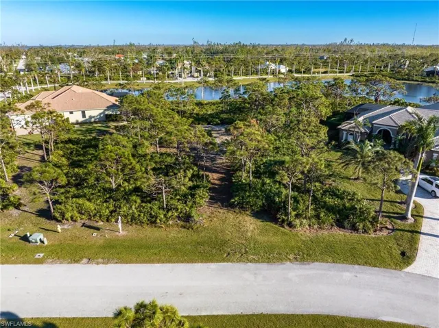 Aerial perspective of suburban area with a tree filled landscape and a large body of water