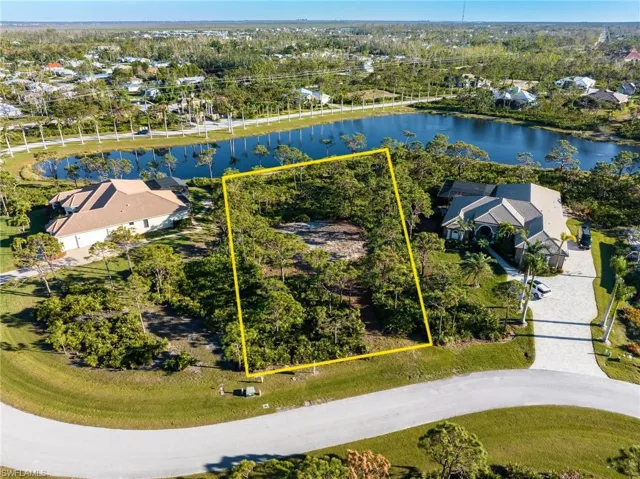 Aerial perspective of suburban area with property boundaries highlighted and a large body of water