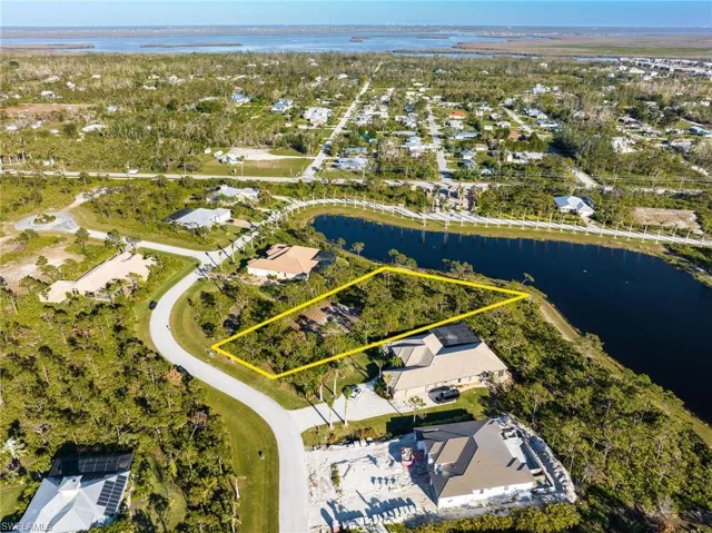 Aerial view of residential area featuring a nearby body of water and property boundaries highlighted